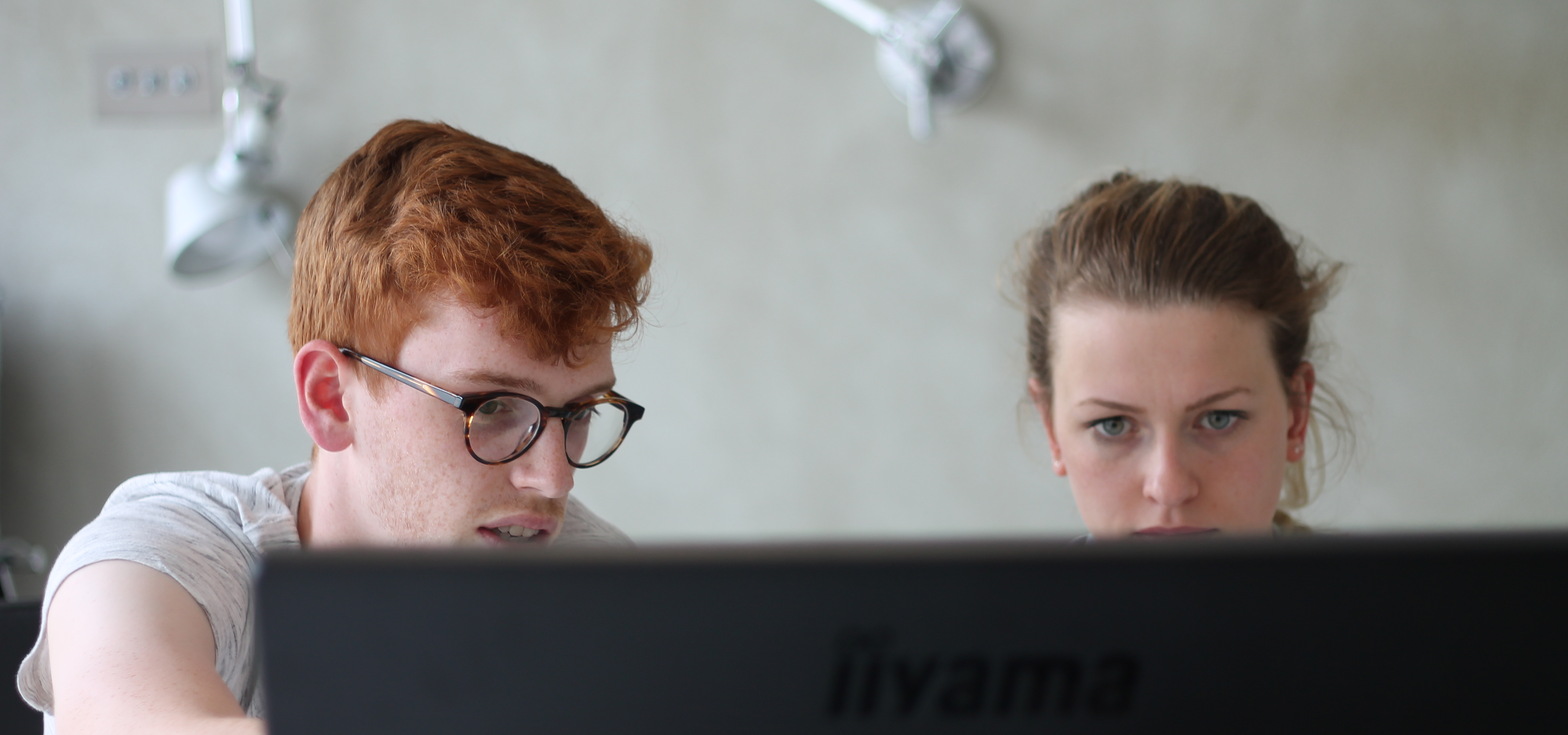 two designers from Rodd Design discussing a project around a monitor