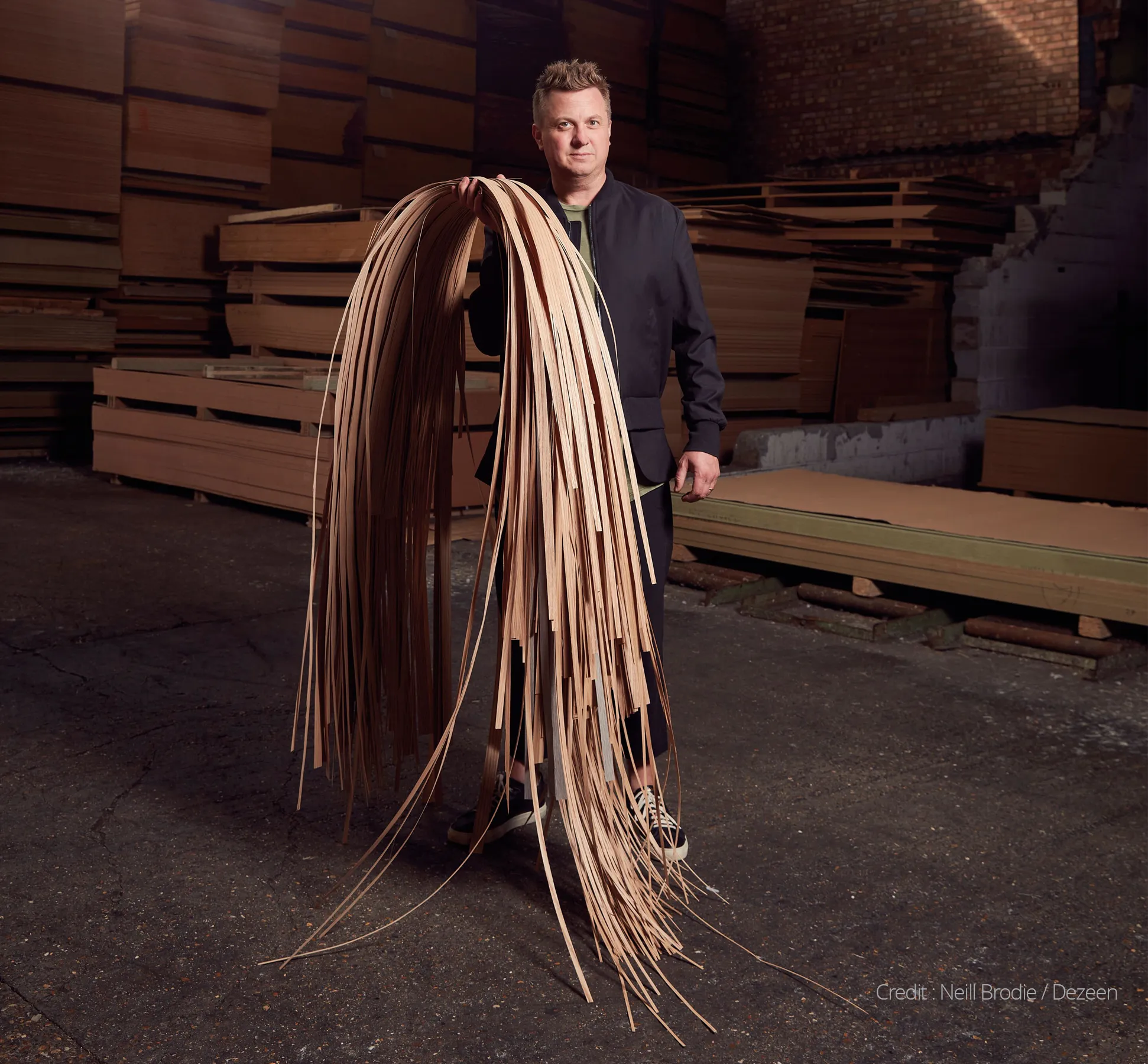Neill Brodie holding reclaimed wood that goes in to making his 'recoil' table