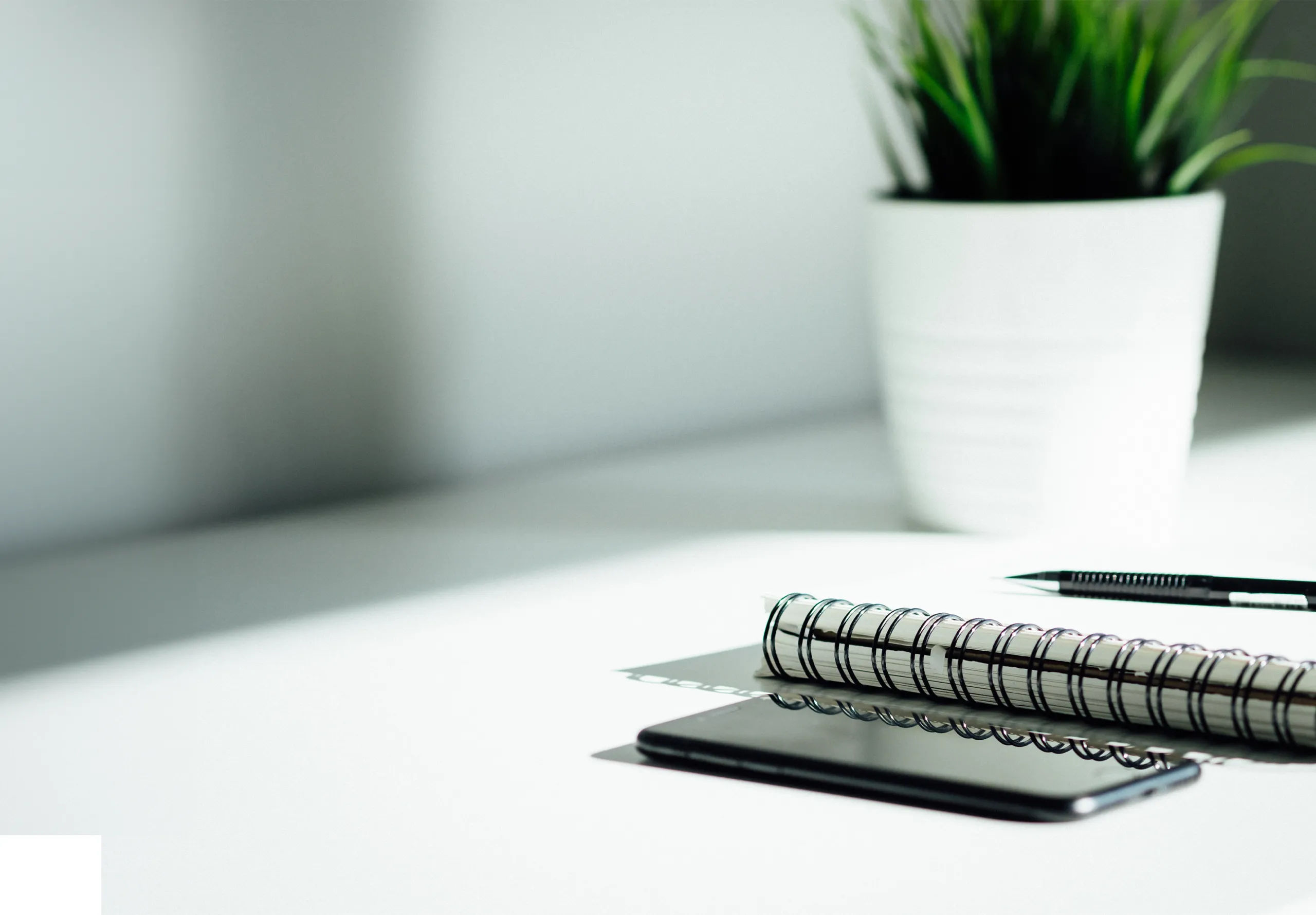 Pen, notebook and phone on a desk