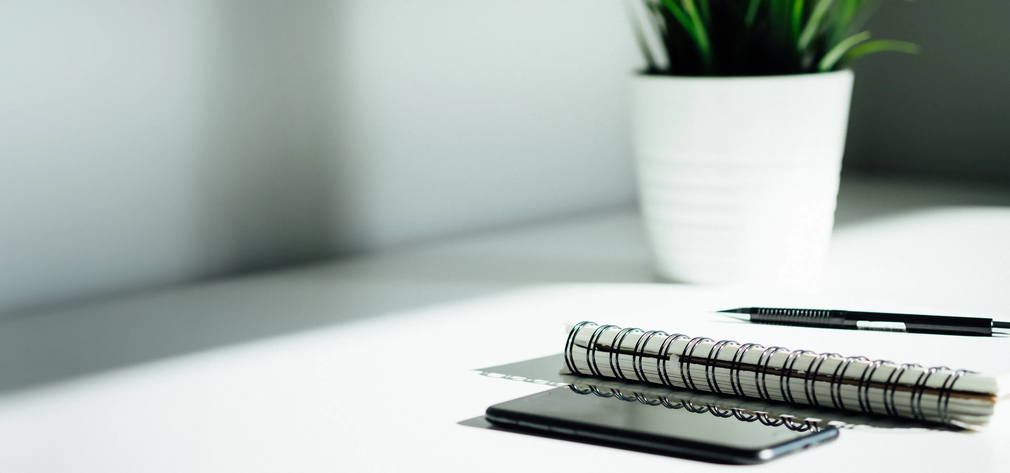 Pen, notebook and phone on a desk
