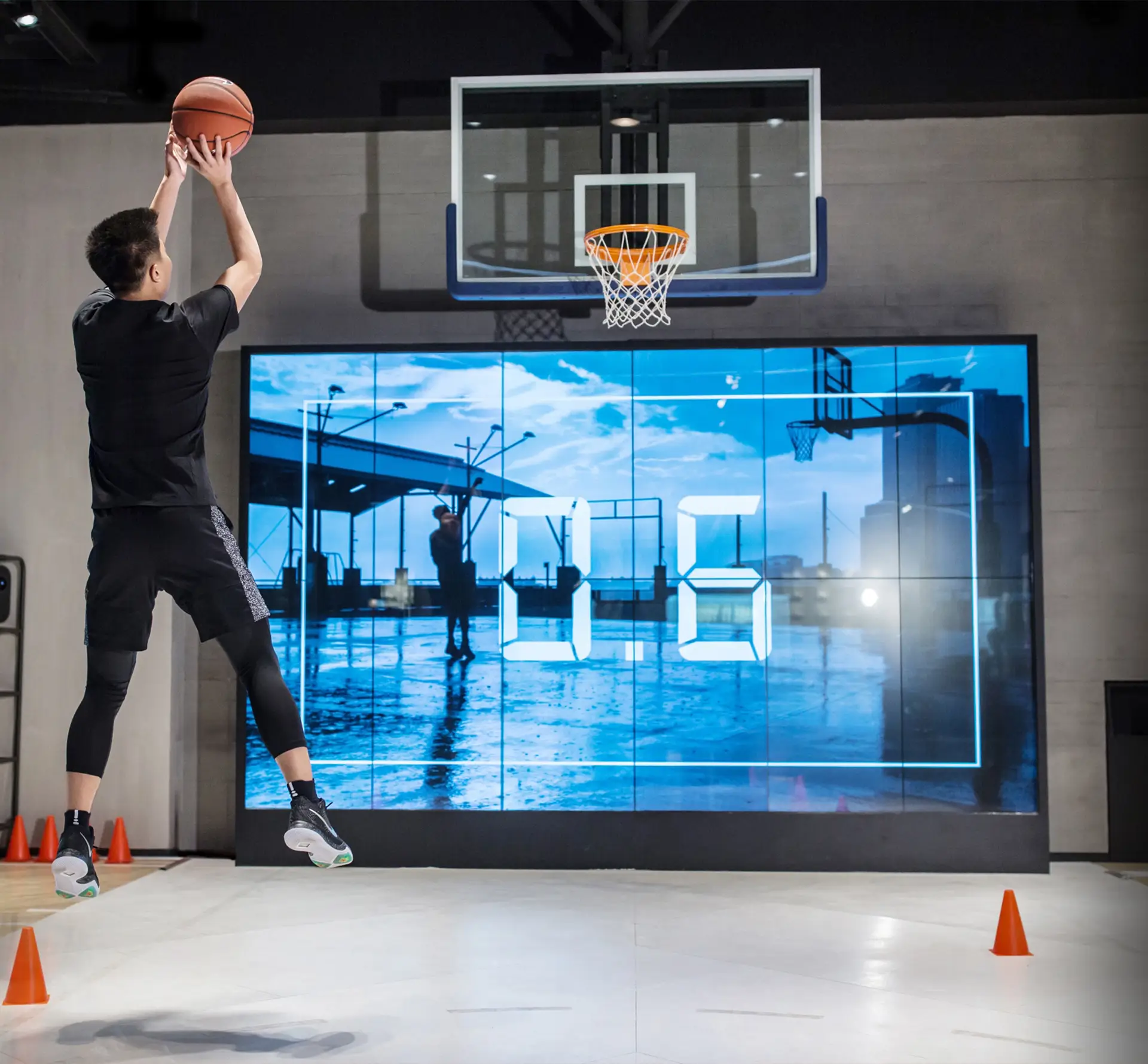 Basketball player making a shot in front of large screen