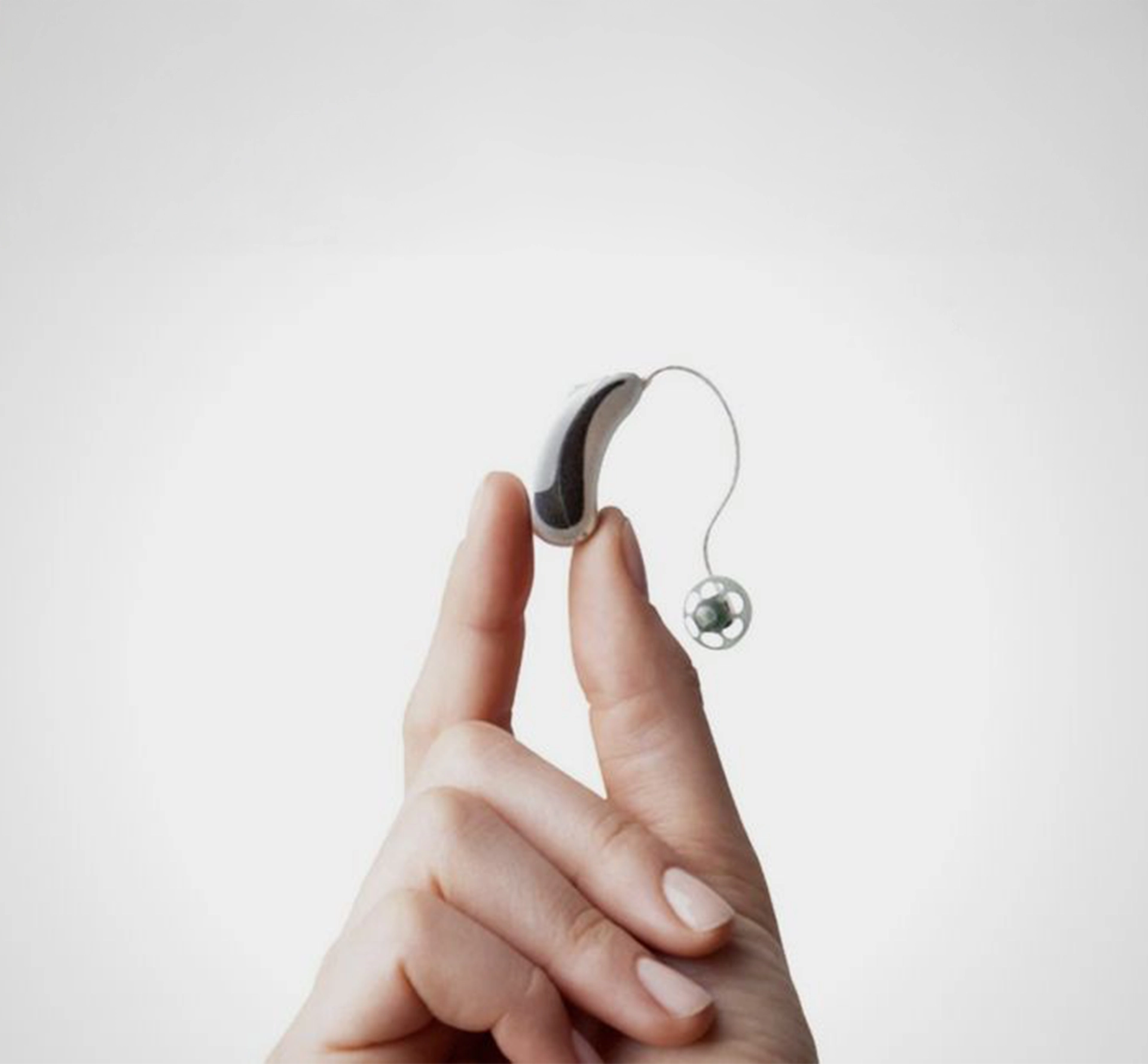Hand holding up a hearing aid