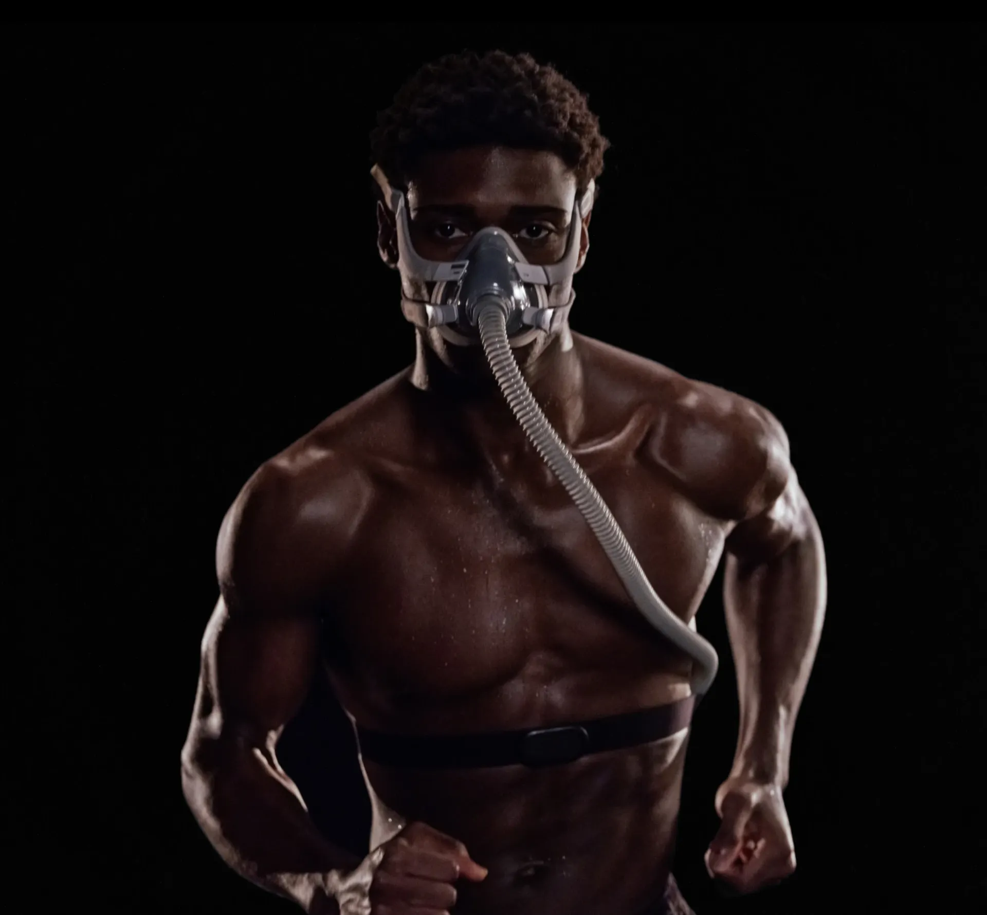 Man running on a treadmill with oxygen mask