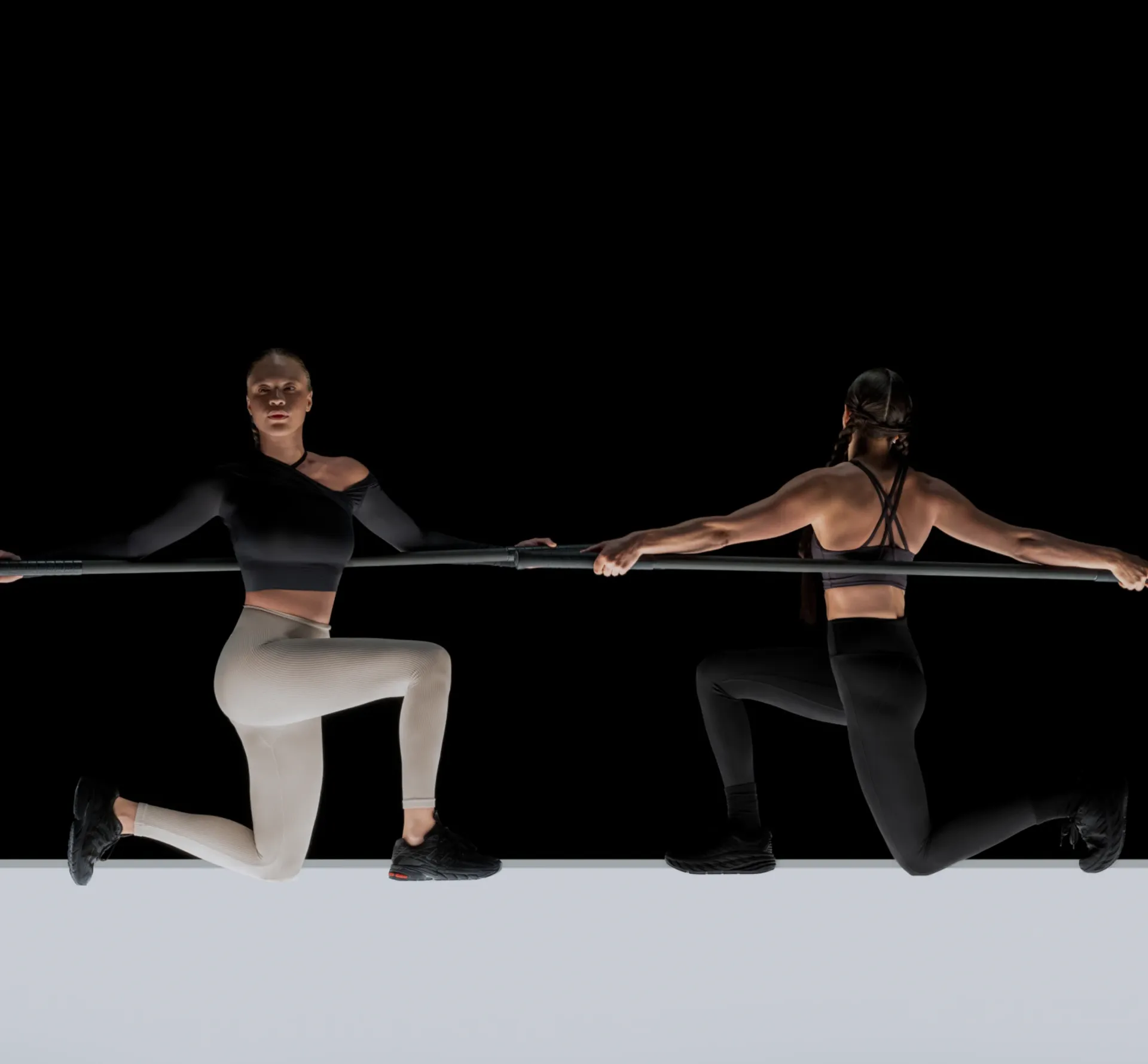 two women training with black poles