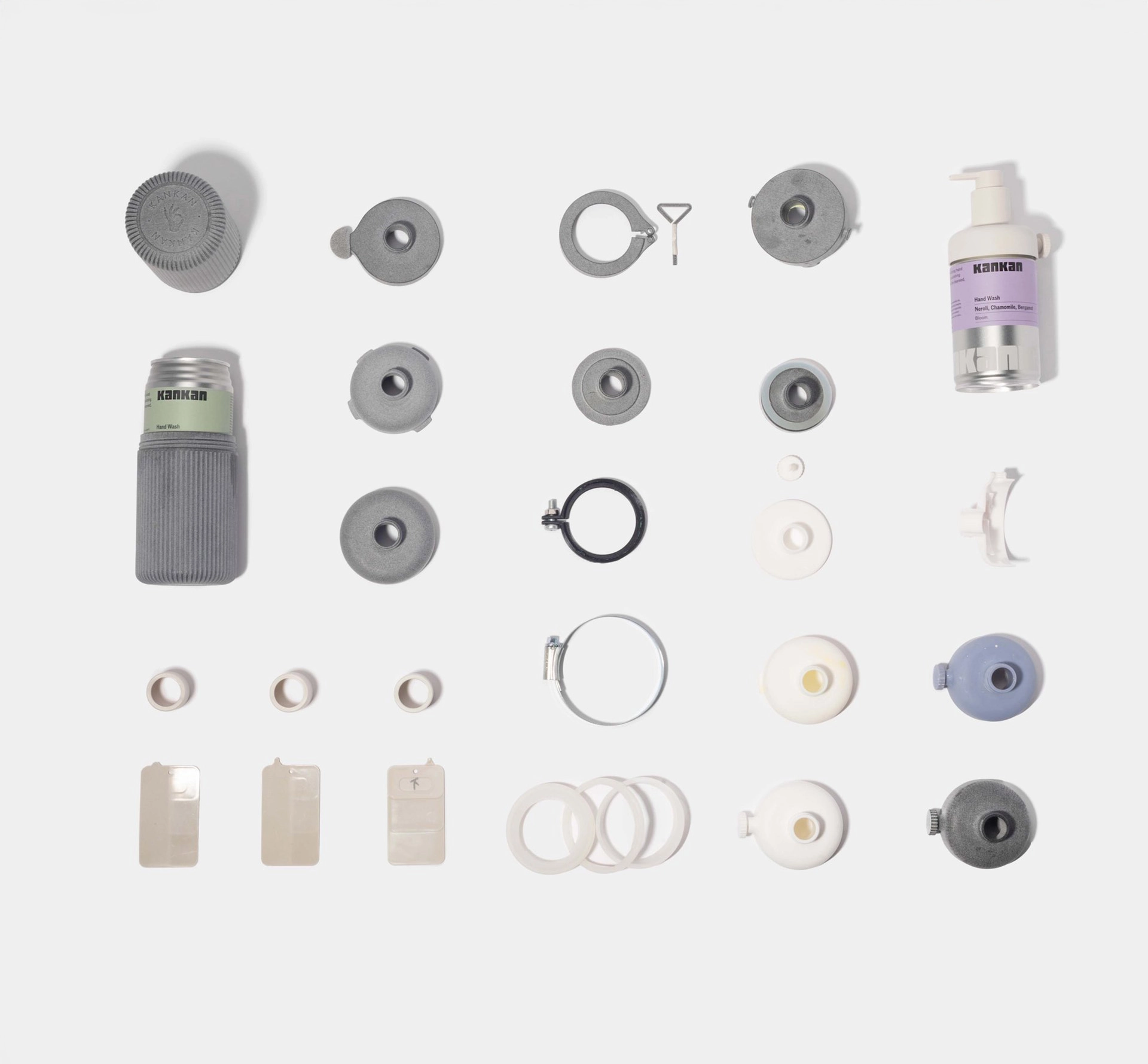 Parts from a bottle dispenser flat lay on white surface