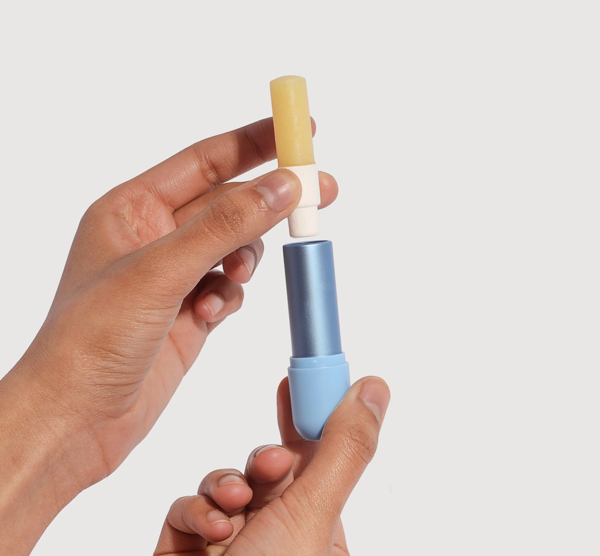 Hands holding and removing lipstick from its case