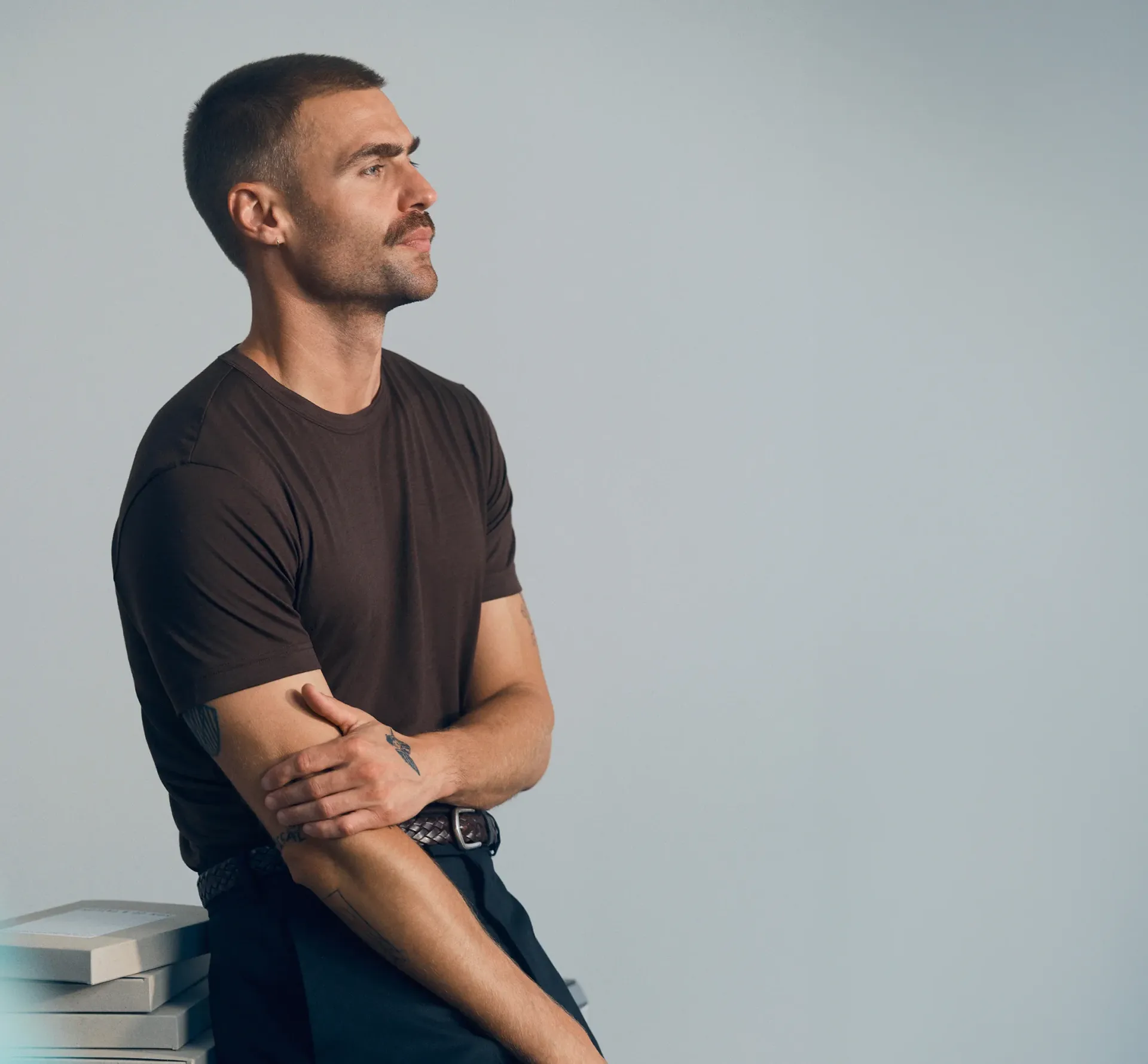 man resting on side of table with grey background