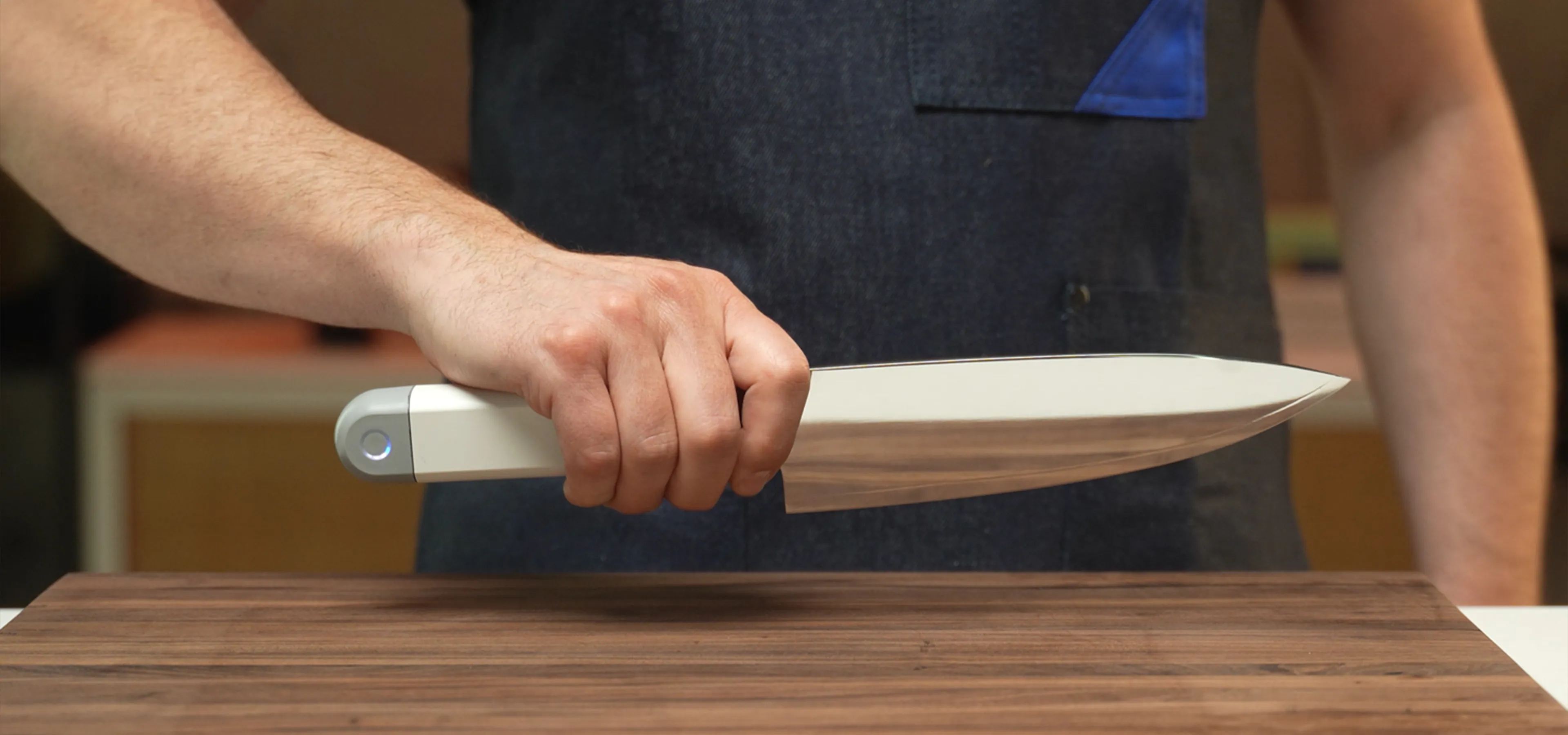 A person in apron holding an ultrasonic knife