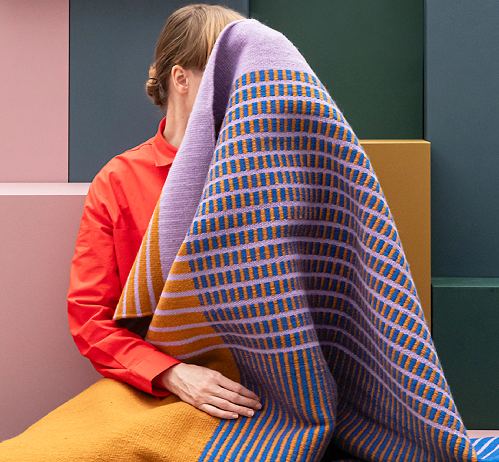 Woman hiding behind a patterned fabric