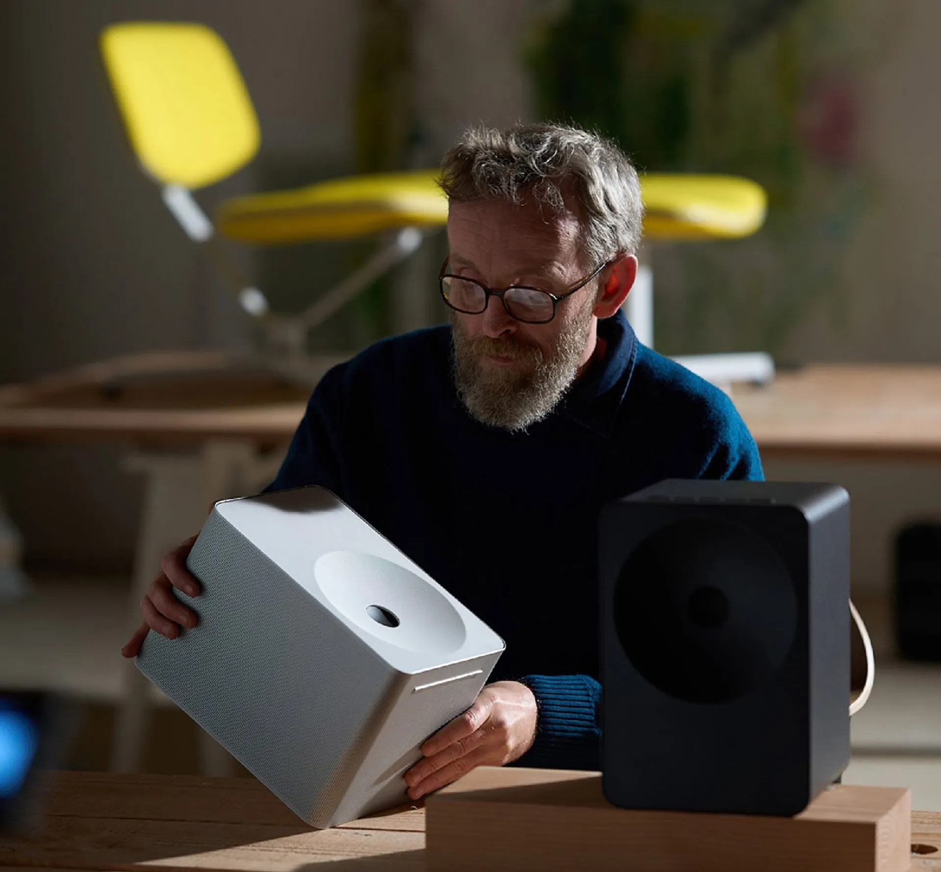 designer holding a white speaker