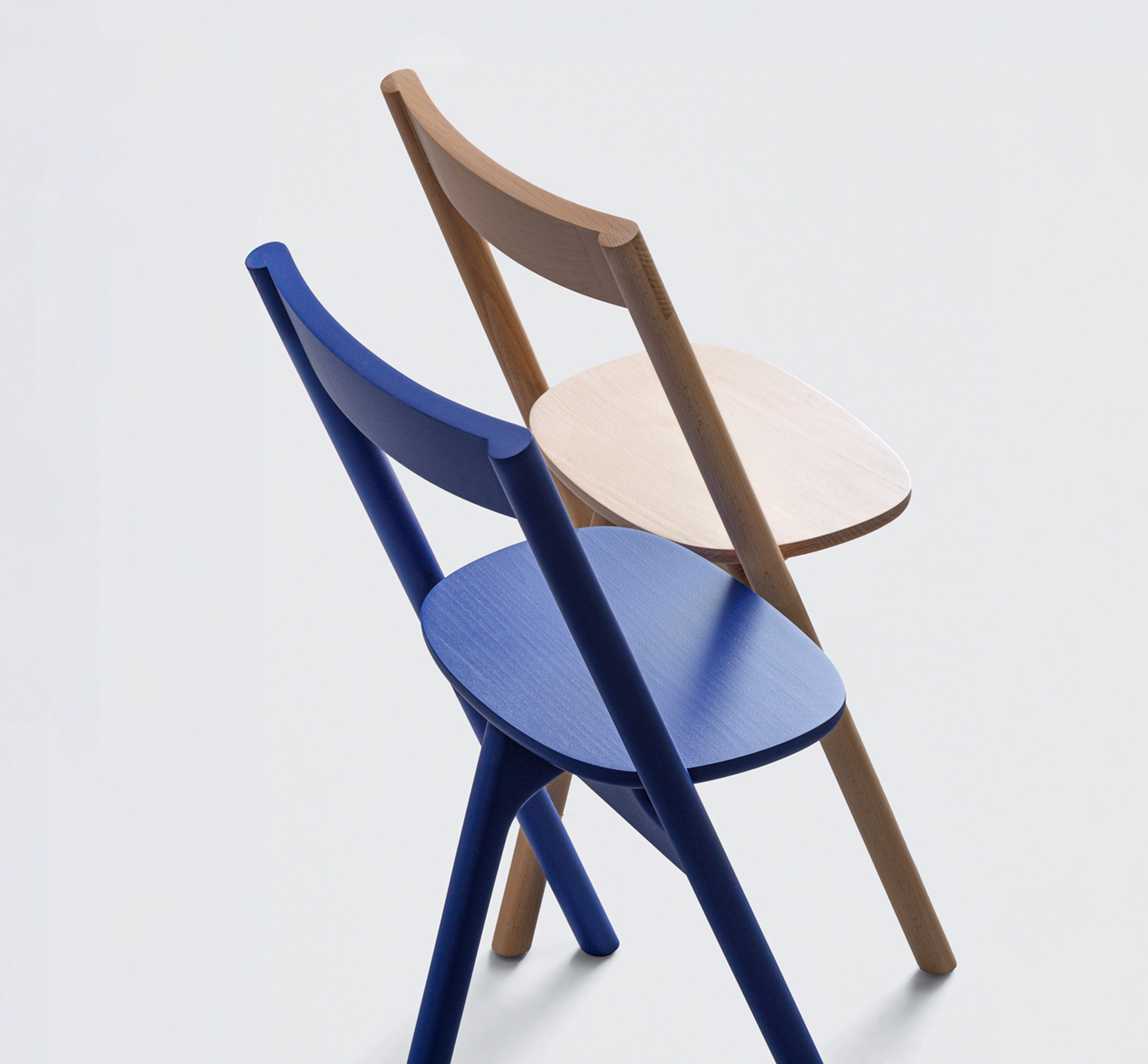 a blue and a natural wood chairs