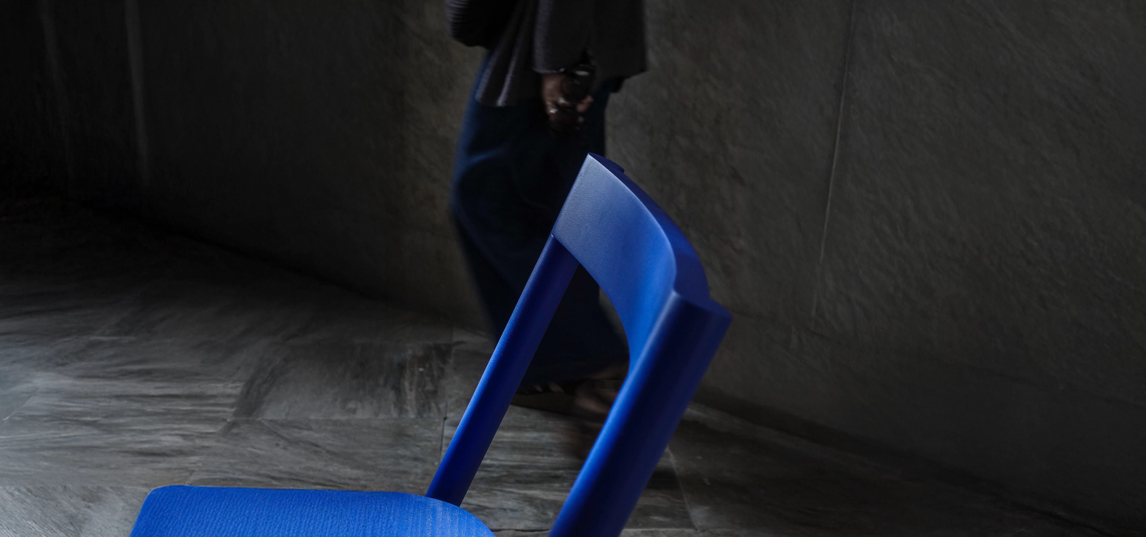 Bright blue chair in a dark room setting