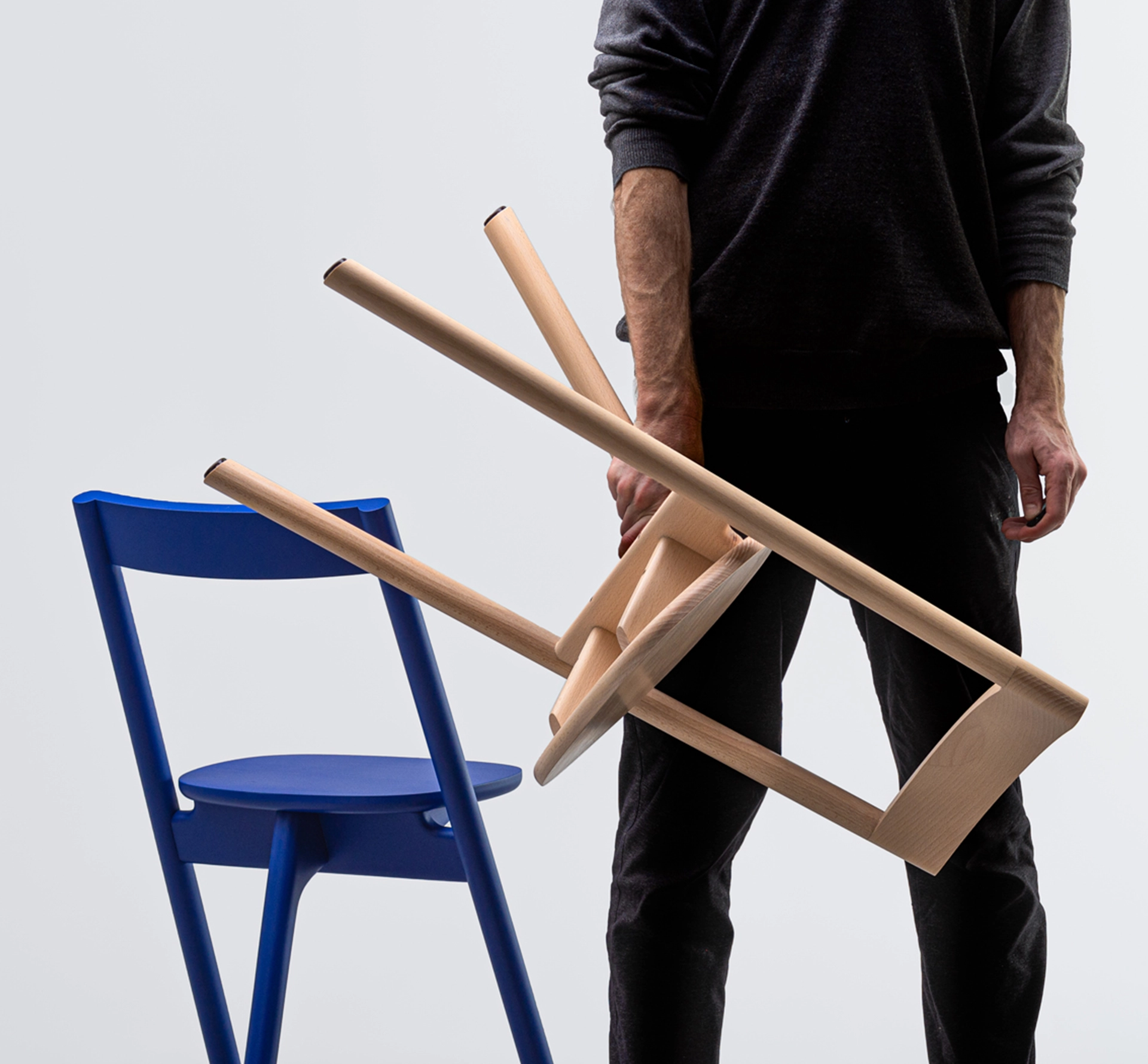 Person holding a wooden chair