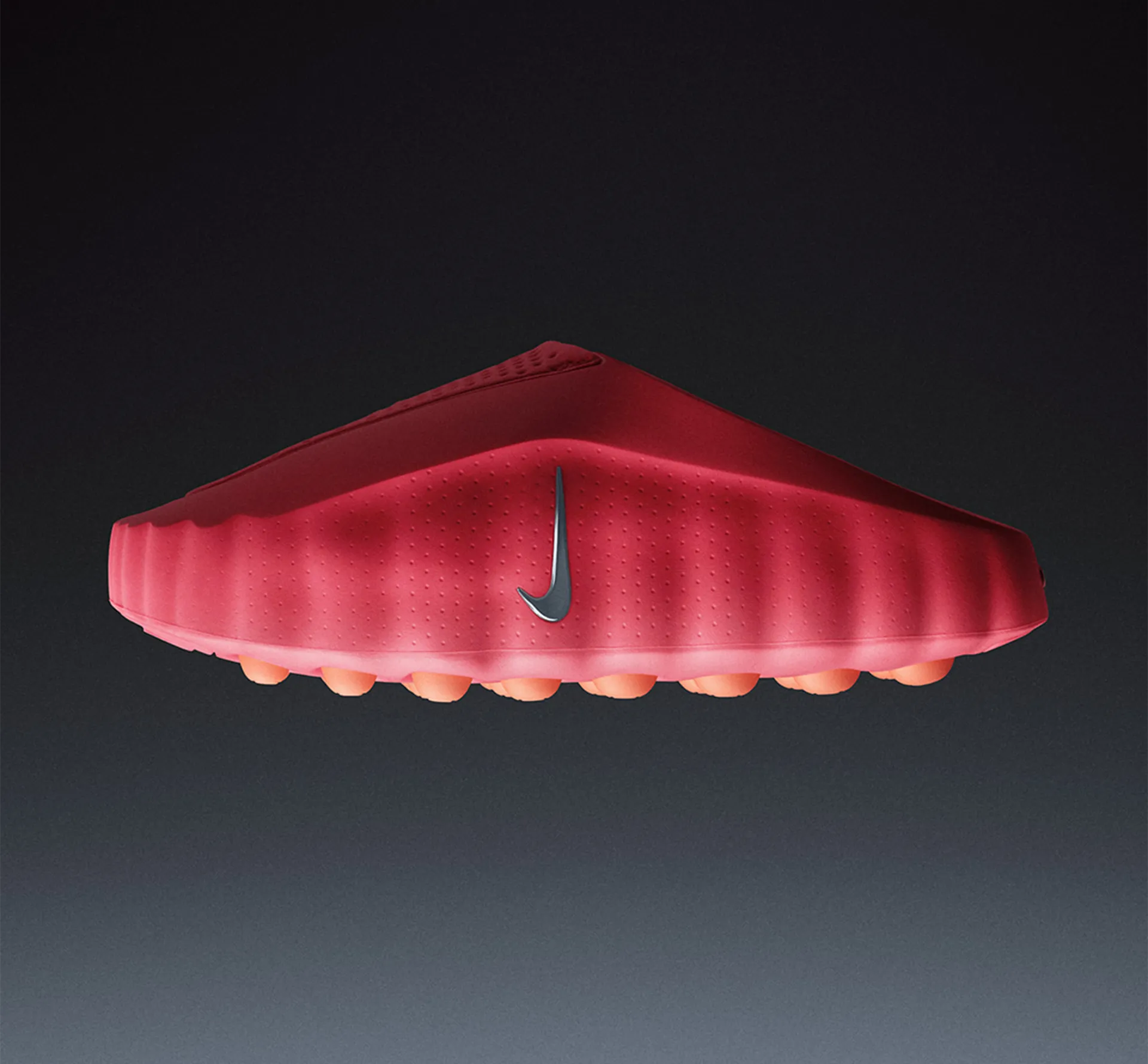 A Nike shoe in red with orange balls for soles